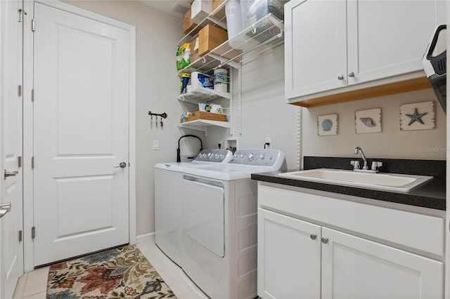 washroom with cabinet space, light tile patterned floors, a sink, and independent washer and dryer