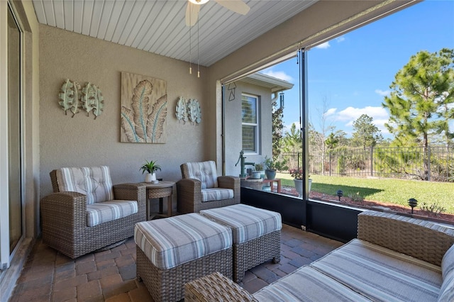 sunroom featuring a ceiling fan