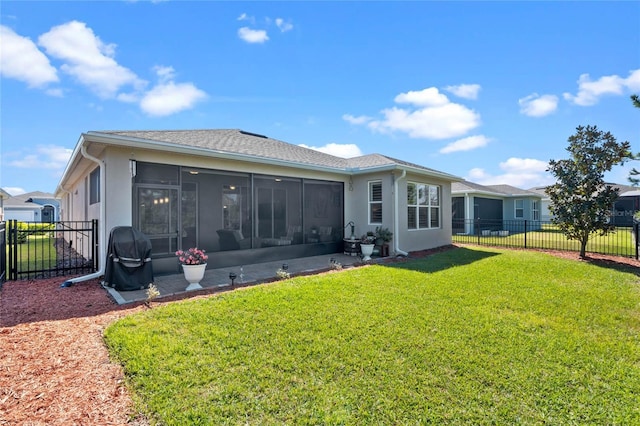 rear view of property with a sunroom, fence, a lawn, and stucco siding