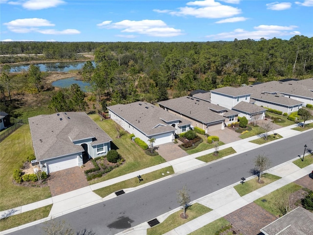 birds eye view of property with a water view and a wooded view