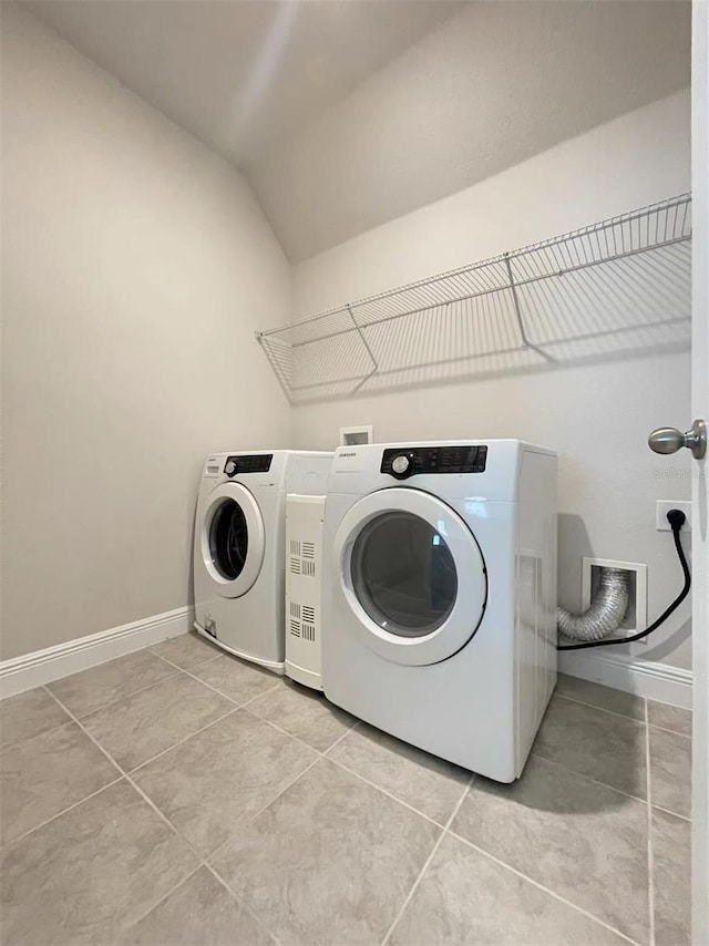 clothes washing area with laundry area, light tile patterned floors, baseboards, and separate washer and dryer