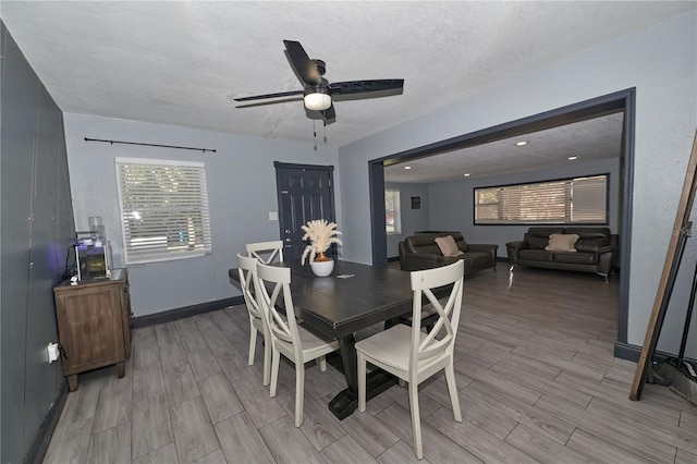 dining room with a healthy amount of sunlight, a ceiling fan, a textured ceiling, and wood finish floors