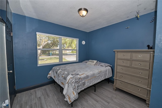 bedroom with wood finished floors and baseboards