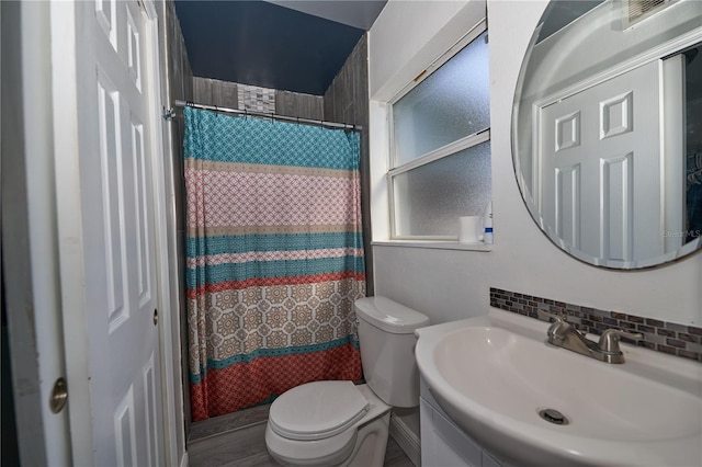 bathroom with vanity, curtained shower, backsplash, and toilet