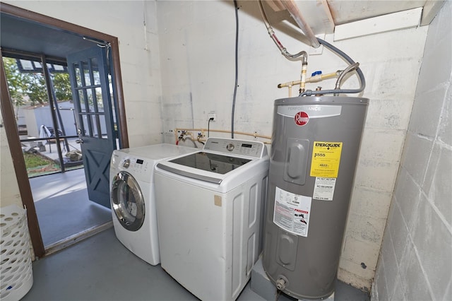 washroom with concrete block wall, laundry area, electric water heater, and washer and clothes dryer