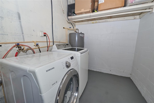 clothes washing area featuring washer and dryer, laundry area, water heater, and concrete block wall