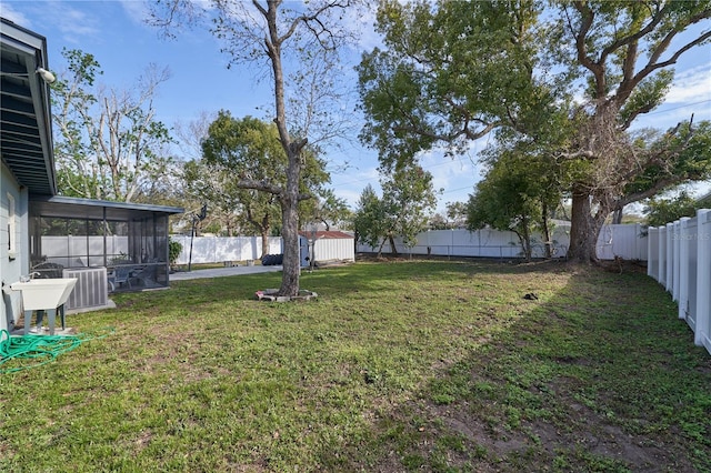 view of yard with central air condition unit, a sunroom, and a fenced backyard