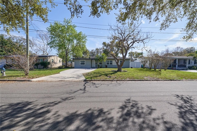 view of front of house with driveway, a front lawn, and fence