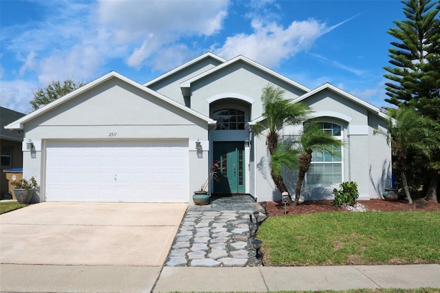 ranch-style home with concrete driveway, an attached garage, and stucco siding