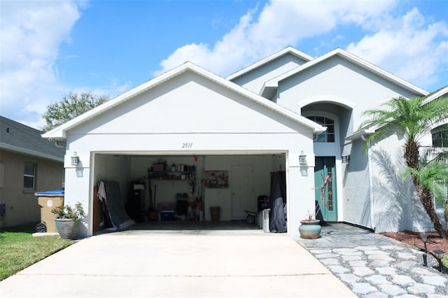 view of front of house with a garage, driveway, and stucco siding