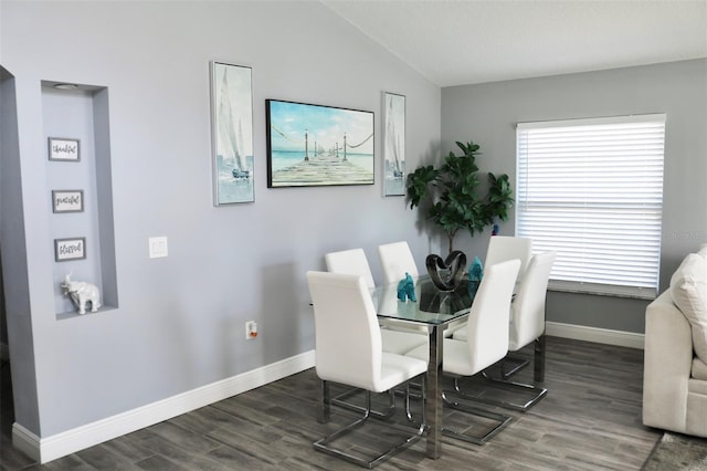 dining space featuring lofted ceiling, baseboards, and wood finished floors