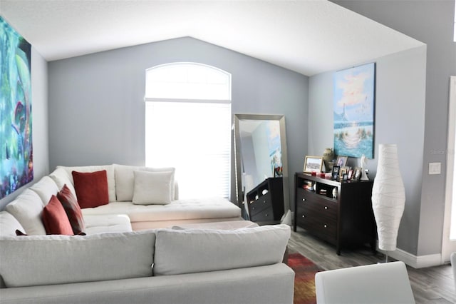 living room featuring baseboards, vaulted ceiling, and wood finished floors