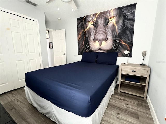 bedroom with baseboards, wood finished floors, visible vents, and a ceiling fan