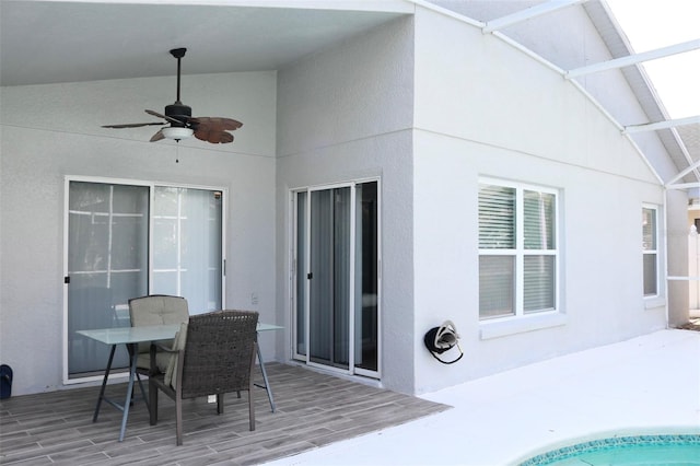 view of patio / terrace with a ceiling fan and glass enclosure