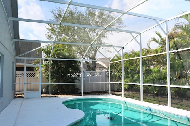 view of swimming pool with a patio, fence, glass enclosure, and a fenced in pool