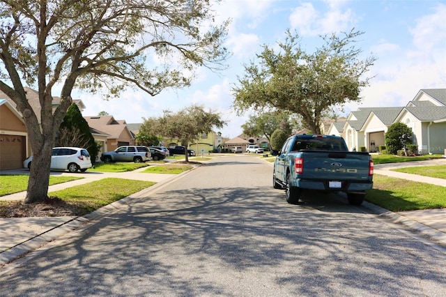 view of road with sidewalks, a residential view, and curbs