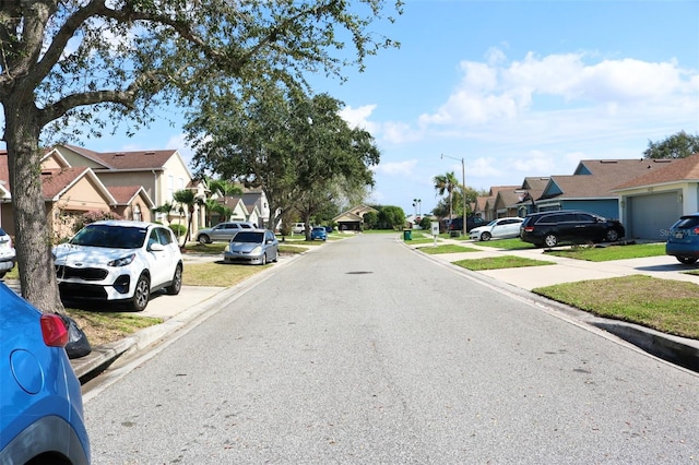 view of street with a residential view, curbs, and street lights