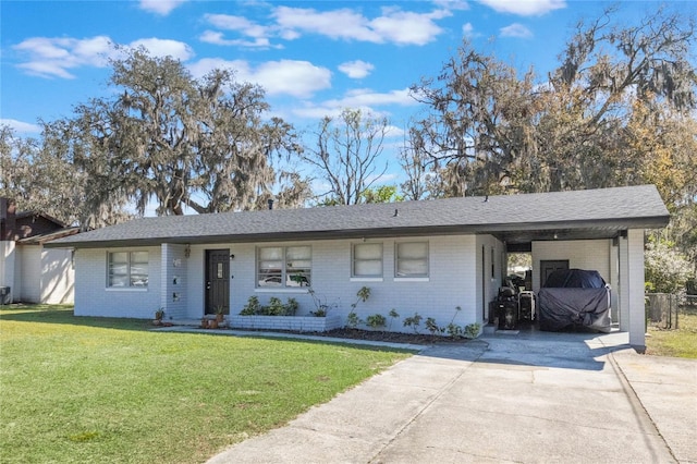 single story home with an attached carport, brick siding, driveway, and a front yard