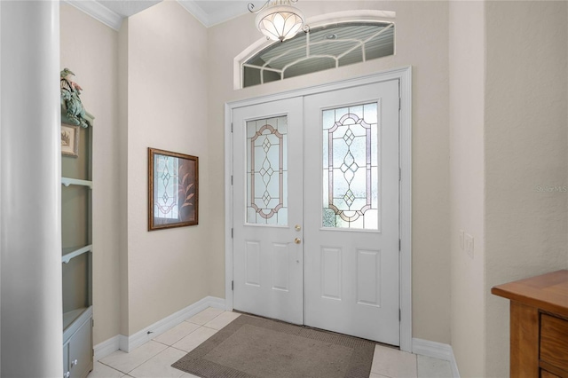 entrance foyer with light tile patterned floors, ornamental molding, and baseboards