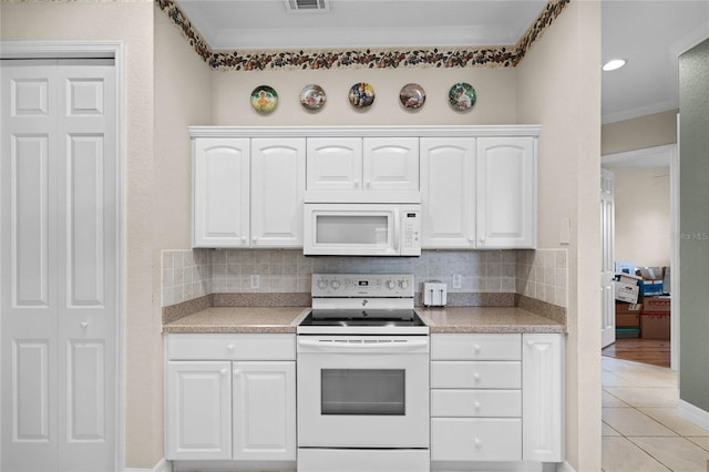 kitchen featuring white appliances, light countertops, and backsplash