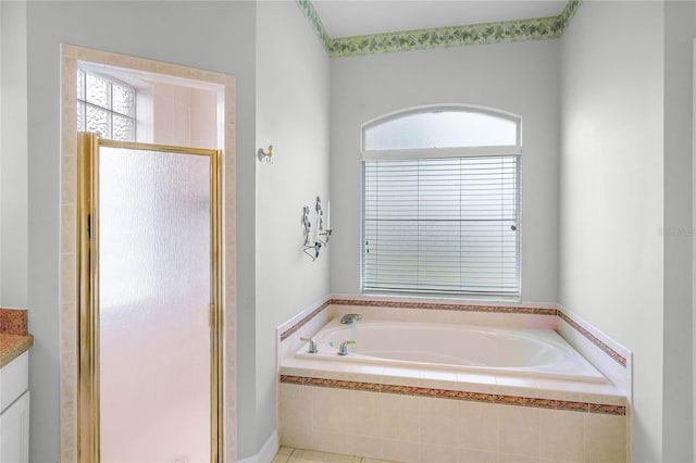 full bathroom with a stall shower, a garden tub, and vanity