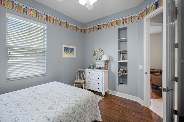 bedroom with ceiling fan, baseboards, and wood finished floors