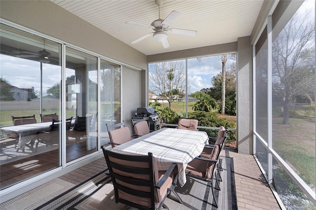 sunroom / solarium featuring ceiling fan