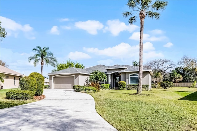 view of front of property with concrete driveway, a front lawn, an attached garage, and stucco siding