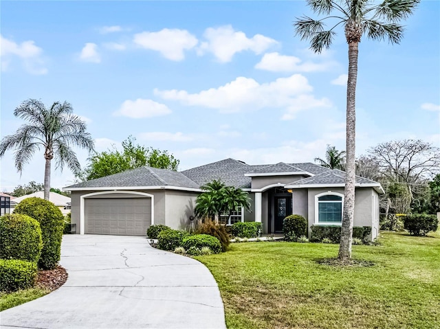 view of front of home featuring an attached garage, driveway, a front yard, and stucco siding