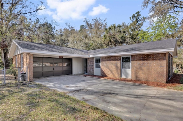 view of front of house with a garage, fence, concrete driveway, and brick siding