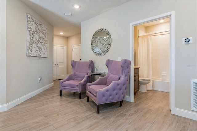 sitting room with light wood-style floors, baseboards, and recessed lighting