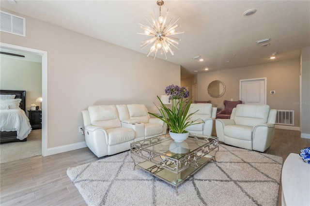 living area with a notable chandelier, baseboards, visible vents, and wood finished floors