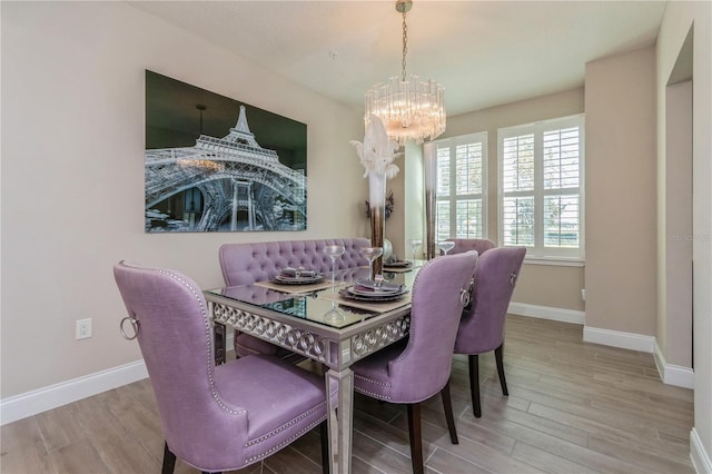 dining room featuring a notable chandelier, wood finished floors, and baseboards