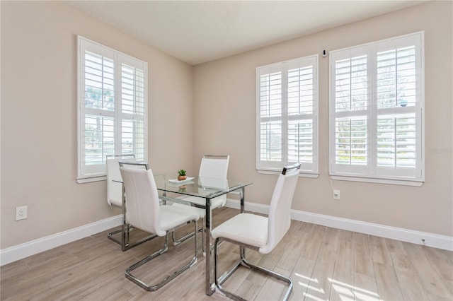 dining room with a wealth of natural light, baseboards, and wood finished floors