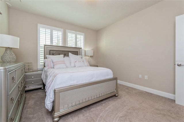 bedroom with dark colored carpet and baseboards