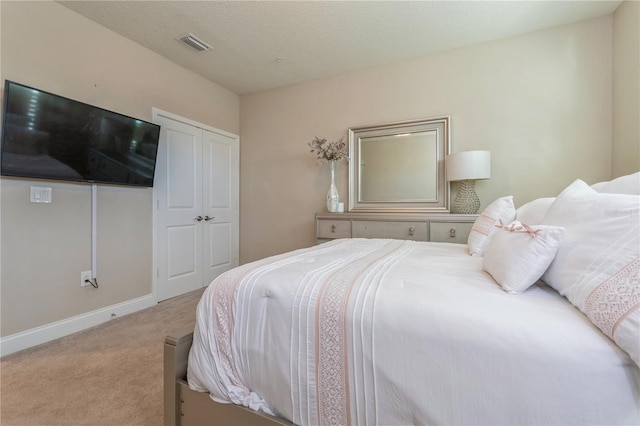 bedroom with light carpet, baseboards, visible vents, and a textured ceiling