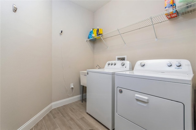 laundry area featuring light wood-type flooring, laundry area, baseboards, and washer and clothes dryer