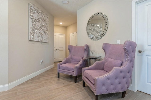 living area with baseboards and wood finished floors