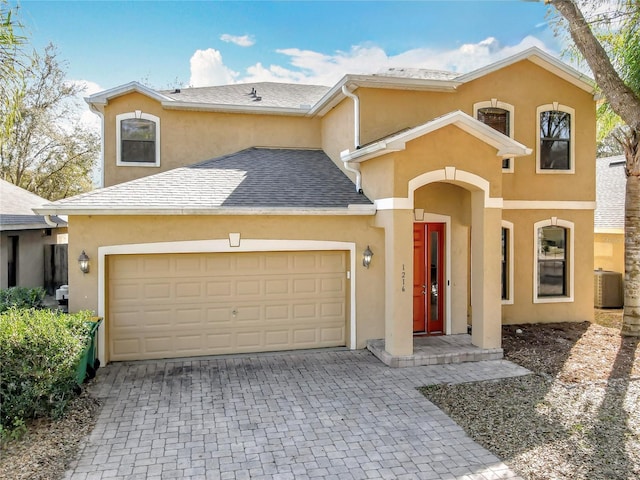 view of front facade featuring a garage, decorative driveway, and stucco siding