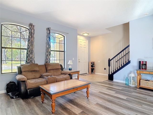 living area with stairway, wood finished floors, and baseboards