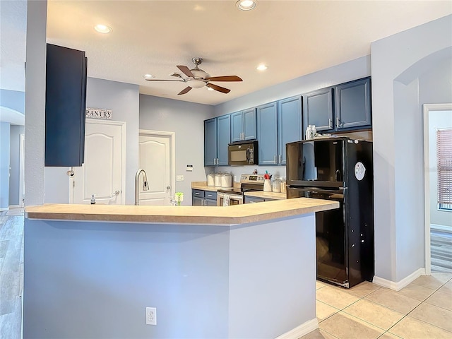 kitchen with light tile patterned floors, ceiling fan, a peninsula, light countertops, and black appliances