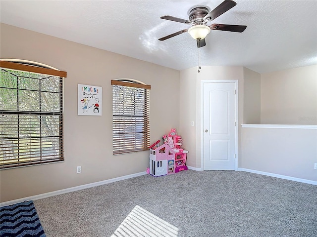 game room featuring a textured ceiling, ceiling fan, carpet, and baseboards