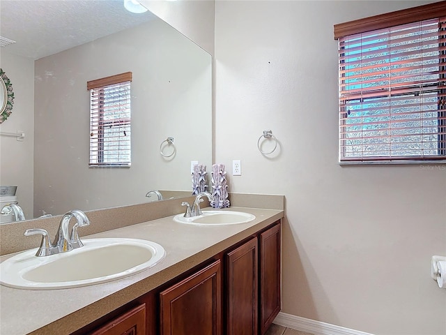 full bathroom with visible vents, a sink, a textured ceiling, and double vanity