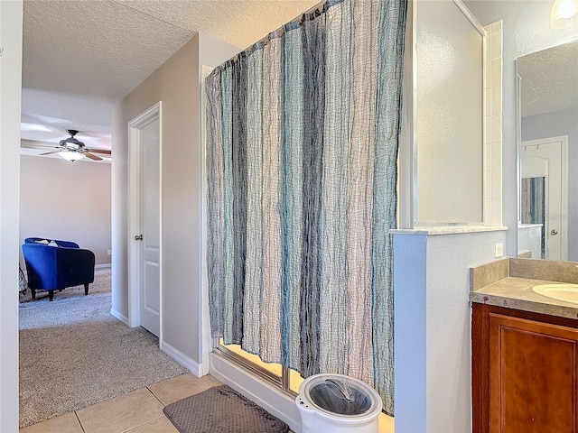 full bathroom featuring a textured ceiling, a shower with shower curtain, vanity, baseboards, and tile patterned floors