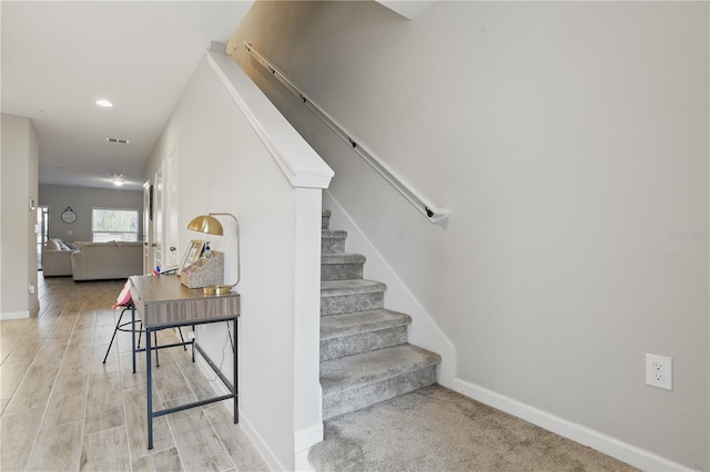 stairway with recessed lighting, wood finished floors, visible vents, and baseboards