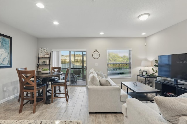 living area featuring recessed lighting, baseboards, and light wood finished floors