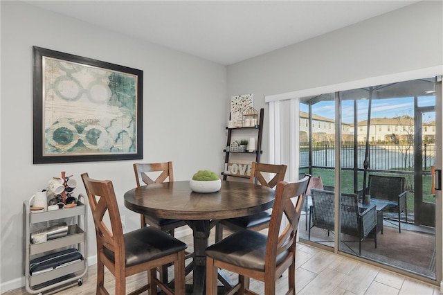 dining room featuring light wood finished floors and baseboards