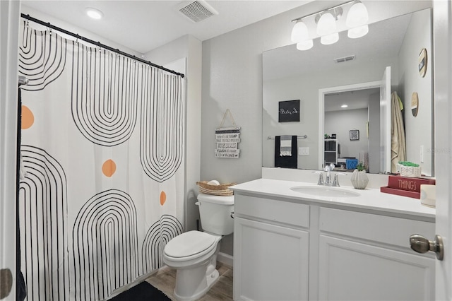 bathroom featuring toilet, visible vents, a shower with shower curtain, and vanity