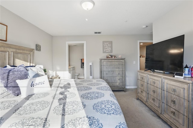 bedroom featuring light carpet, ensuite bathroom, visible vents, and baseboards