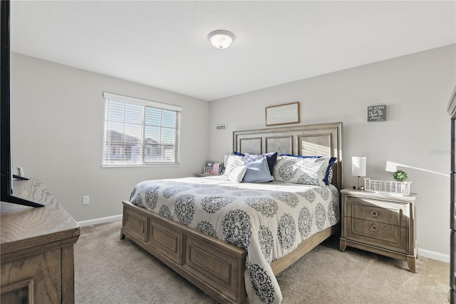 bedroom featuring light carpet and baseboards